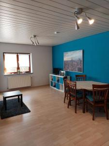 a room with a table and chairs and a blue wall at Ferienwohnung am Stiefel in Sankt Ingbert