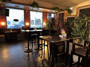 a restaurant with two tables and some plants at Village Inn & Suites in Sarnia