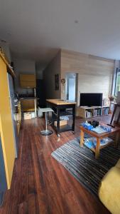 a living room with a table and a couch at T1 duplex centre Argeles Gazost in Argelès-Gazost
