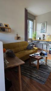 a living room with a green couch and a table at T1 duplex centre Argeles Gazost in Argelès-Gazost