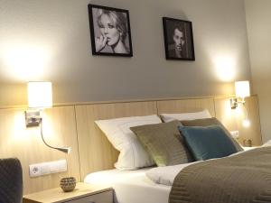 a bedroom with a bed with two pictures on the wall at Das LENNI in Büren