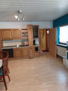 a large kitchen with wooden cabinets and a window at Ferienwohnung am Stiefel in Sankt Ingbert