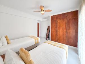 a bedroom with two beds and a wooden cabinet at Apartment Praia Rocha Candimar Sunflower in Portimão