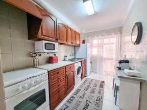 a kitchen with wooden cabinets and a washer and dryer at Apartment Praia Rocha Candimar Sunflower in Portimão