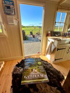 a book sitting on the floor in front of a door at Coorie and Keek Shepherd's Hut in Prestrie
