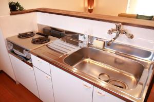 a kitchen with a stainless steel sink and a stove at TOMOSHIBI Kurashiki Zen House Near Bikan Historical Quarter 美観地区近く 和モダン一棟貸し in Kurashiki +36 photos