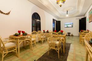 a dining room with wooden tables and chairs at Riad Zinaida in Aït Bou Zguia