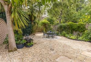 a patio with a table and chairs in a garden at Middle Chine - Beautiful Garden and Spacious Living Space in Bournemouth +29 photos