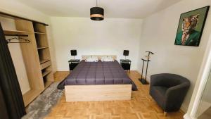 a bedroom with a bed and a chair in it at Gîte Champgrand in Loriol-sur-Drôme