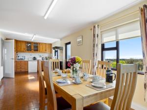 a kitchen and dining room with a wooden table and chairs at Little Tara, Ballyconneely in Ballyconneely