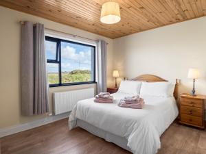 a bedroom with a large bed with towels on it at Little Tara, Ballyconneely in Ballyconneely