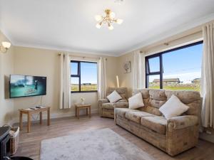 a living room with a couch and two chairs at Little Tara, Ballyconneely in Ballyconneely
