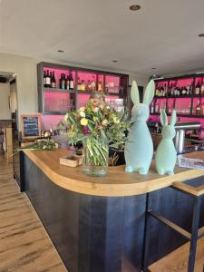 a bar with two rabbits and a vase of flowers at Das LENNI in Büren +12 photos