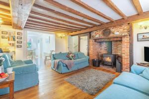 a living room with blue couches and a fireplace at 3 Bed in Southwold oc-hsmugg in Southwold