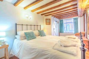 a bedroom with a large white bed with blue pillows at 3 Bed in Southwold oc-hsmugg in Southwold