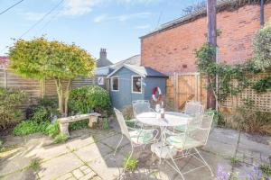a patio with a table and chairs in a yard at 3 Bed in Southwold oc-hsmugg in Southwold
