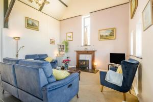 a living room with blue furniture and a fireplace at 3 Bed in Little Ellingham oc-2147 in Rockland Saint Peter