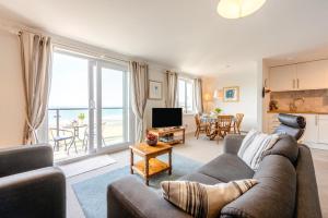 a living room with a couch and a view of the ocean at 2 Bed in Putsborough oc-flat31 in Croyde