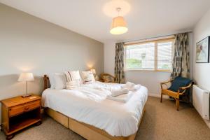 a bedroom with a large white bed and a window at 2 Bed in Putsborough oc-flat31 in Croyde +21 photos