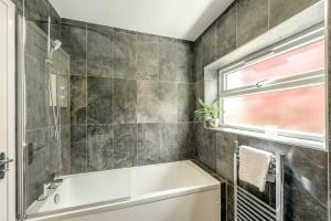a bathroom with a tub and a window at 4 Bed in Bideford oc-76452 in Parkham +26 photos