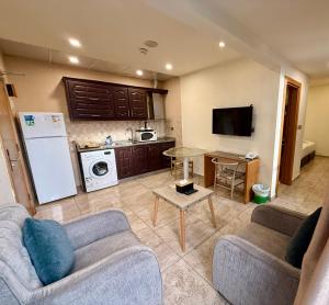 a living room with two couches and a kitchen at Jawheret S Hotel Suite in Amman