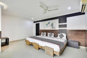 a bedroom with a large bed with a wooden headboard at Collection O Elite Residency in Chennai