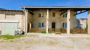 a house with a wooden fence in front of it at Gîte Champgrand in Loriol-sur-Drôme