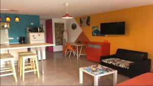 a living room with a couch and a kitchen with a counter at La Villa Belle in Biscarrosse