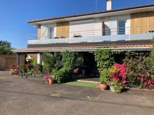 a house with plants and flowers in front of it at La Villa Belle in Biscarrosse