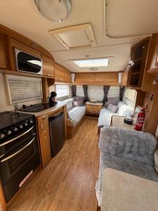 a kitchen and living room in an rv at Little Hideaway Deluxe in Costa da Caparica