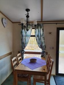 a dining room table with chairs and a window at Stenshemmet Holidayhome in Hjo