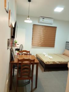 a room with a table and a bed and a table and chairs at Axc cozy inn in Olongapo