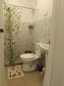 a bathroom with a toilet and a shower curtain at Axc cozy inn in Olongapo