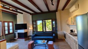 a living room with a blue couch and a kitchen at Villa Elizabeth Apartments in Ouranoupoli