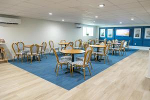 a dining room with tables and chairs and blue walls at Surf Side Hotel in Nags Head +130 photos