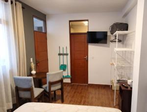 a room with a table and chairs and a door at Tu Refugio de Descanso a Pasos de Todo in Cochabamba