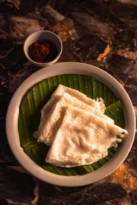 a bowl of food on a green plate at Nautical 9 Beach Retreat in Kundapur