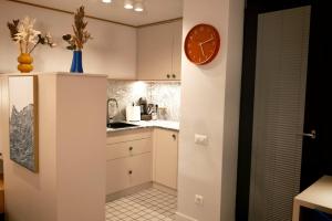 a kitchen with white cabinets and a clock on the wall at Apartament Studio - Târgu Neamț ,Premium Hotel Style in Târgu Neamț +34 photos