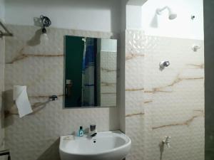 a bathroom with a white sink and a mirror at CANAAN MUSIC Hotel in Moratuwa