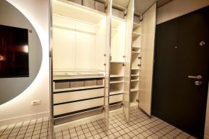 a walk in closet with white cabinets and a mirror at Apartament Studio - Târgu Neamț ,Premium Hotel Style in Târgu Neamț