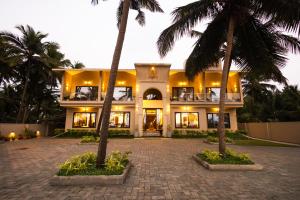 a building with palm trees in front of it at Nautical 9 Beach Retreat in Kundapur