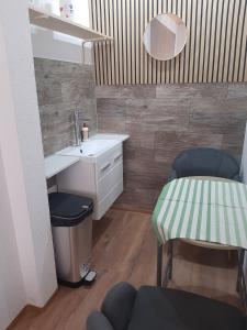 a bathroom with a sink and a table and a chair at Doppelbett Zimmer mit Boxspringbett in Weiden