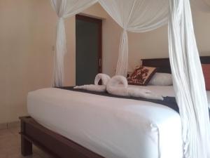 En eller flere senge i et værelse på Pondok Dhevika and Warung
