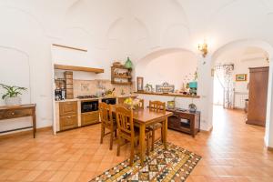 a large kitchen with a wooden table and chairs at La dimora degli Dei in Praiano