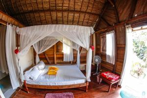 a bedroom with a bed with a canopy at Antafondro Lodge in Sainte Marie