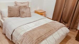 a bedroom with a large white bed with pillows at Casa Paz in Alcabideche