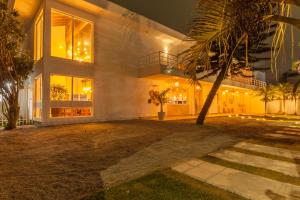 a large house with a palm tree in front of it at Almaê Pousada in Matinhos