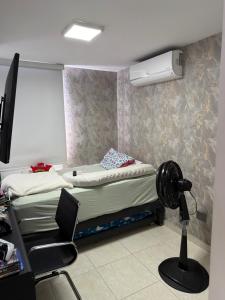 ein Schlafzimmer mit Bett und Schreibtisch mit Ventilator in der Unterkunft Manhattan PH in Cúcuta