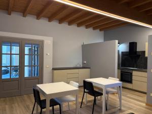 a kitchen with two tables and chairs and a refrigerator at Dimora Federica in Erbusco