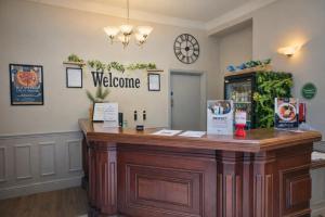 a welcome counter in a room with a clock on the wall at The County Hotel in Carlisle